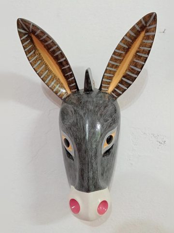 Máscara de burro gris de frente, con orejas largas de franjas claras, ojos ámbar y hocico blanco con fosas rosas